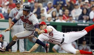 Atlanta Braves&#39; Martin Prado, left, is run down on his way to the plate by Washington Nationals third baseman Ryan Zimmerman (11) during the eighth inning of the first baseball game of a doubleheader, Saturday, July 21, 2012, in Washington. The Braves won 4-0. (AP Photo/Carolyn Kaster)
