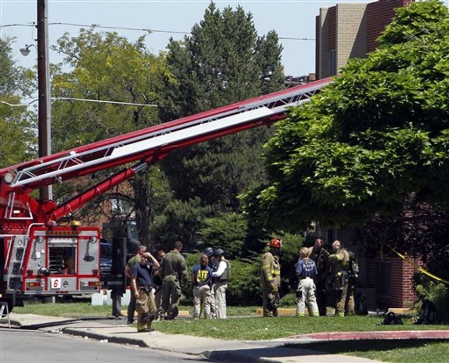 Firefighters and police gather after an explosion could be heard outside the apartment of James Holmes in Aurora, Colo., Saturday, July 21, 2012. Federal authorities detonated one small explosive and disarmed another inside Holmes' apartment, but several other explosive devices remained, said Aurora police Sgt. Cassidee Carlson. Twelve people were killed and dozens were injured in a shooting attack early Friday at a packed movie theater during a showing of the Batman movie, "The Dark Knight Rises." Police have identified Holmes, 24, as the suspected shooter. (AP Photo/Ed Andrieski)
