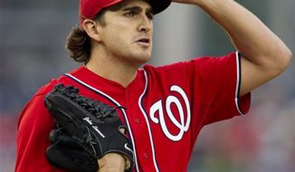 Washington Nationals starting pitcher John Lannan pauses in the first inning during the second baseball game of a doubleheader against the Atlanta Braves, Saturday, July 21, 2012. Lannan gave up two runs in the first inning but none in the next six in a game the Nationals went on to win 5-2. (AP Photo/Carolyn Kaster)