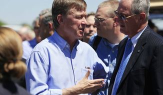 ** FILE ** Colorado Gov. John Hickenlooper, left, confers with Steve Hogan, mayor of Aurora, Colo., before a news conference at the Century 16 theater east of the Aurora Mall in Aurora, Colo., on Friday, July 20, 2012. (AP Photo/David Zalubowski)