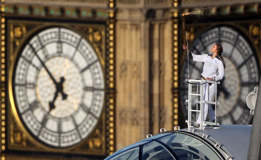 Amelia Hempleman-Adams poses with the Olympic Flame on top of a London Eye pod on the Torch Relay leg through London. (Associated Press)