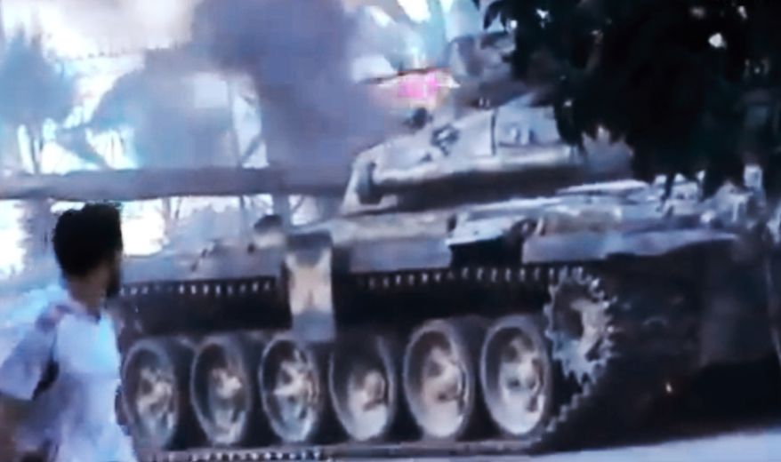 In this image made from amateur video released by the Ugarit News and accessed Monday, July 23, 2012, a Free Syrian Army soldier looks at a Syrian military that caught on fire during clashes with Syrian government troops in Aleppo, Syria. The Syrian regime acknowledged for the first time Monday that it possessed stockpiles of chemical and biological weapons and said it will only use them in case of a foreign attack and never internally against its own citizens. The Associated Press cannot independently verify the content, date, location or authenticity of this material. (AP Photo/Ugarit News via AP video)
