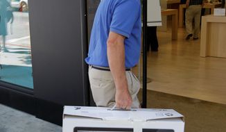 **FILE** An Apple customer returns a 21.5-inch iMac computer to an Apple Store in Palo Alto, Calif. (Associated Press)