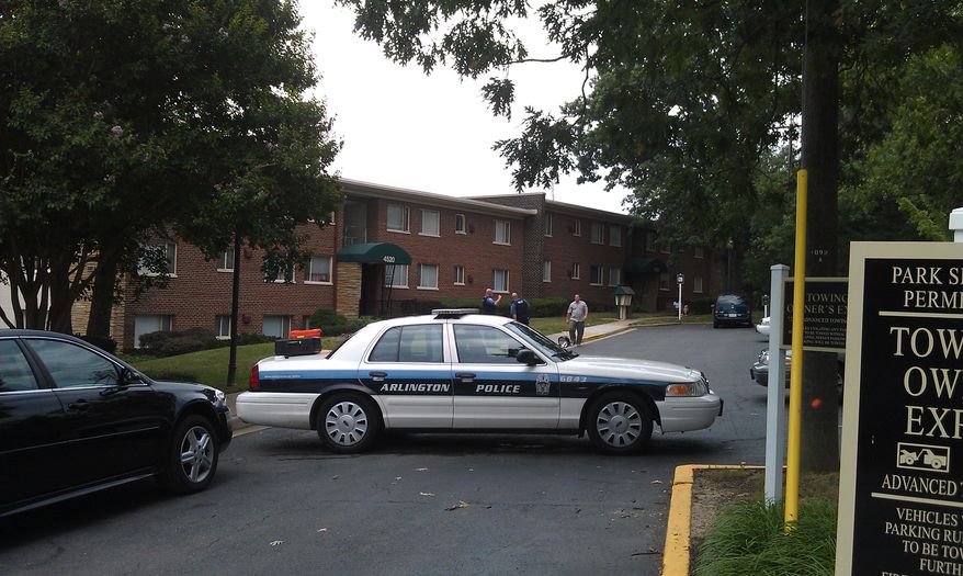 Police officers restrict access to a Shirlington apartment complex where a man and woman were found dead in an apparent murder-suicide (Charity Corkey/The Washington Times)