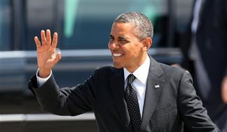 President Obama waves upon his arrival, Tuesday, July 24, 2012, at the 142nd Fighter Wing Oregon Air National Guard Base, in Portland, Ore. Mr. Obama is in Oregon to raise money for his re-election campaign. (AP Photo/Rick Bowmer)