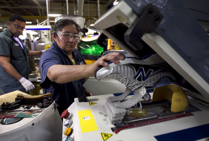 **FILE** Worker Maria Contrero removes an elite running shoe from a sole press May 1, 2012, during the assembly process at the New Balance Athletic Shoe, Inc. factory in Boston. (Associated Press)