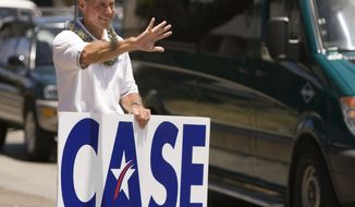 **FILE** Former Hawaii Rep. Ed Case holds a sign May 22, 2010, as he campaigns in Honolulu. (Associated Press)