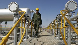 ** FILE ** Iranian oil technician Majid Afshari makes his way to the oil separator facilities in Iran&#39;s Azadegan oil field southwest of Tehran on April 15, 2008. (Associated Press)