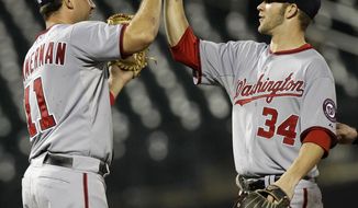 Washington Nationals third baseman Ryan Zimmerman (11) and right fielder Bryce Harper (34) celebrate after the Nationals defeated the New York Mets 8-2 in ten innings in their baseball game at Citi Field in New York, Monday, July 23, 2012. (AP Photo/Kathy Willens)