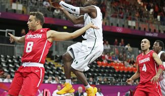 Nigeria&#39;s Tony Skinn, center, drives to the basket behind Tunisia&#39;s Marouan Kechrid, left, during a basketball game at the 2012 Summer Olympics, Sunday, July 29, 2012, in London. At right is Tunisia&#39;s Radhouane Slimane. (AP Photo/Charles Krupa)