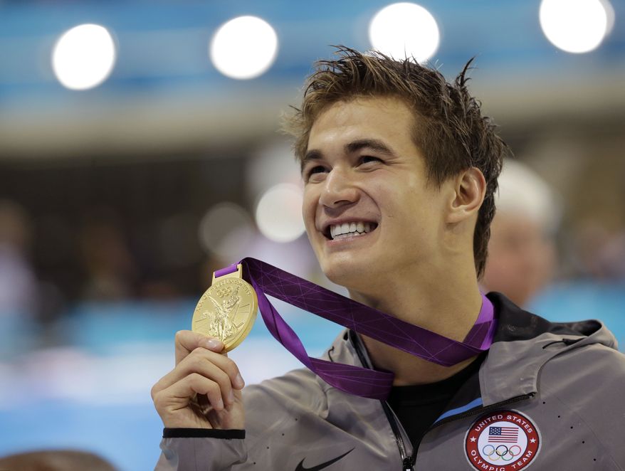 United States' Nathan Adrian poses with his gold medal for the men's 100-meter freestyle swimming final at the Aquatics Centre in the Olympic Park during the 2012 Summer Olympics in London, Wednesday, Aug. 1, 2012. (AP Photo/David J. Phillip)