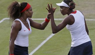 Serena Williams, left, and Venus Williams of the United States clasp hands as they compete against Sorana Cirstea and Simona Halep of Romania in women&#39;s doubles at the All England Lawn Tennis Club in Wimbledon, London at the 2012 Summer Olympics, Monday, July 30, 2012. (AP Photo/Elise Amendola)