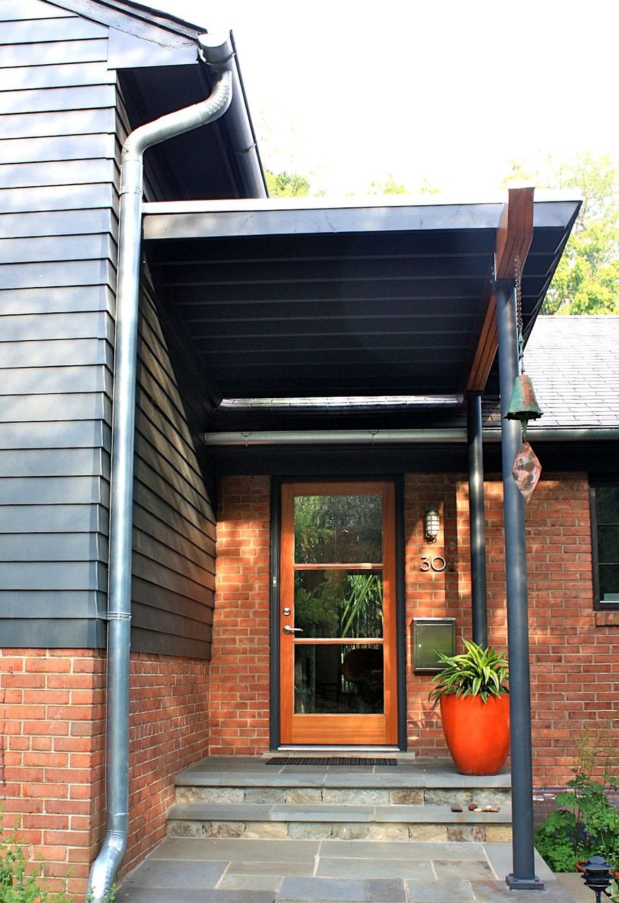 Enhancing a home’s curb appeal does not have to mean undertaking a large project such as replacing siding. Bethesda Architect David Benton revamped the front of his home by replacing a solid wood front door with a glass door and adding new gutters and a new portico entrance.
