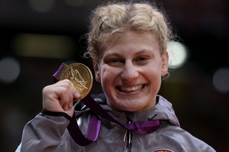 Kayla Harrison, of the United States, holds up her gold medal after the women's 78-kg judo competition at the 2012 Summer Olympics, Thursday, Aug. 2, 2012, in London. (AP Photo/Paul Sancya)