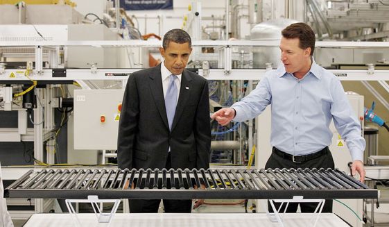 **FILE** President Obama, accompanied by Solyndra CEO Chris Gronet, looks at a solar panel during a May 26, 2010, tour of Solyndra Inc., a solar panel manufacturing facility, in Fremont, Calif. (Associated Press)