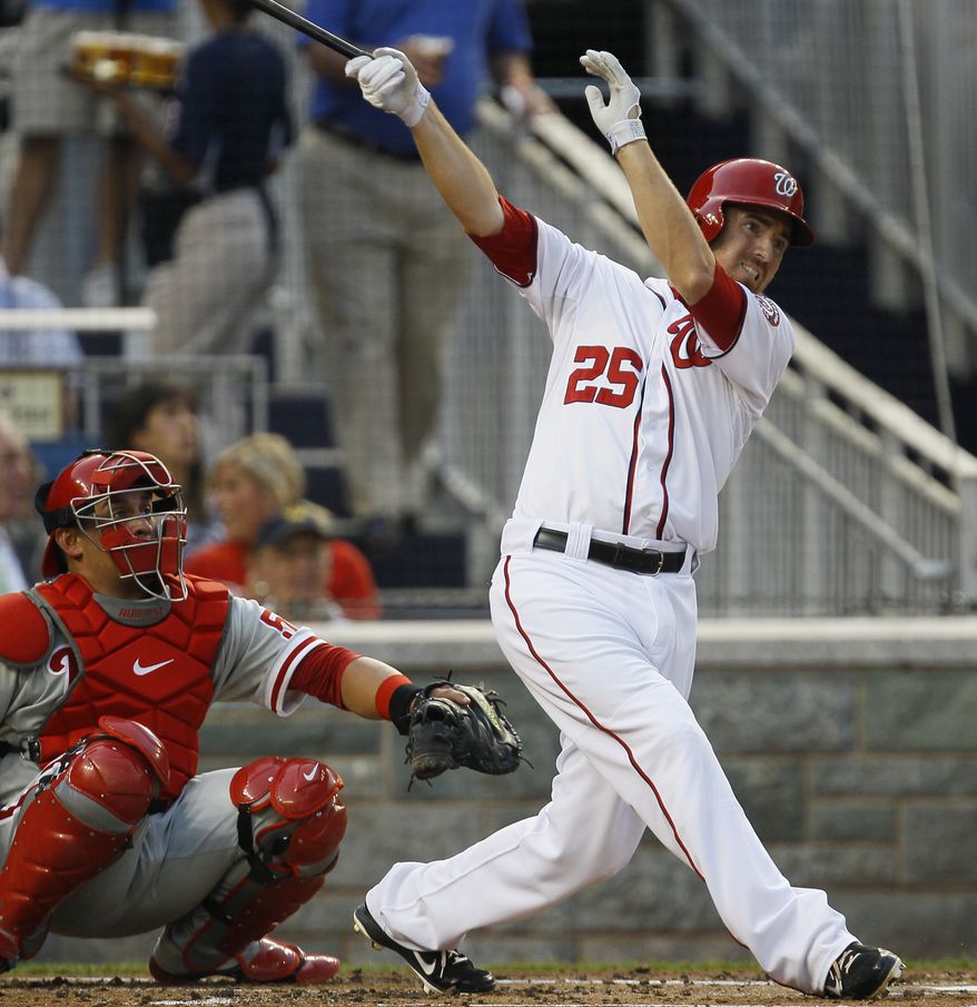 Washington Nationals' Adam LaRoche follows through on a home run as Philadelphia Phillies catcher Carlos Ruiz (51) watches during the second inning of a baseball game, Thursday, Aug. 2, 2012, in Washington. (AP Photo/Carolyn Kaster)