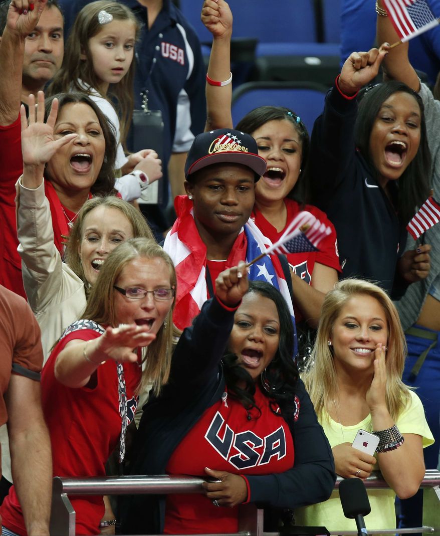 Natalie Hawkins, bottom center, mother of U.S. gymnast Gabrielle Douglas, waves her country's flag and cheers for her gold medallist daughter during the artistic gymnastics women's individual all-around competition at the 2012 Summer Olympics, Thursday, Aug. 2, 2012, in London. At right is Shawn Johnson, the 2008 Olympic individual all-around gymnastics silver medal winner. (AP Photo/Matt Dunham)