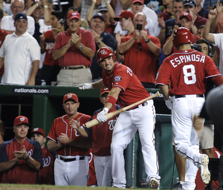 Washington Nationals' Ryan Zimmerman, center, awaits the arrival of teammate Danny Espinosa (8) after Espinosa hit a three-run home run in the eighth inning of a baseball game against the Florida Marlins at Nationals Park, Saturday, Aug. 4, 2012, in Washington. The Nationals won 10-7. (AP Photo/Richard Lipski)