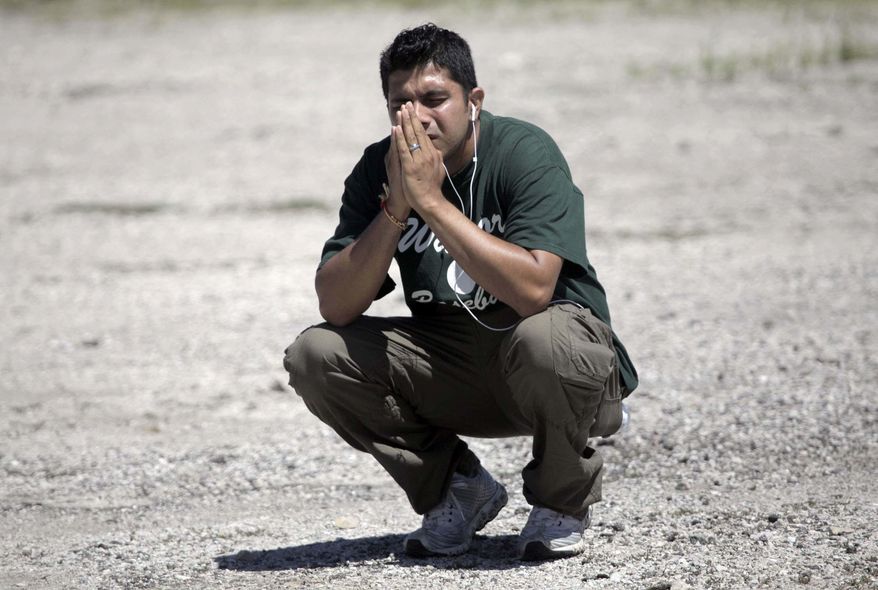A family member waits to hear information about his loved ones inside the Sikh Temple on South Howell Avenue where a shooting occurred, Sunday, Aug. 5, 2012, in Oak Creek, Wis. (AP Photo/Milwaukee Journal-Sentinel, Mike De Sisti)