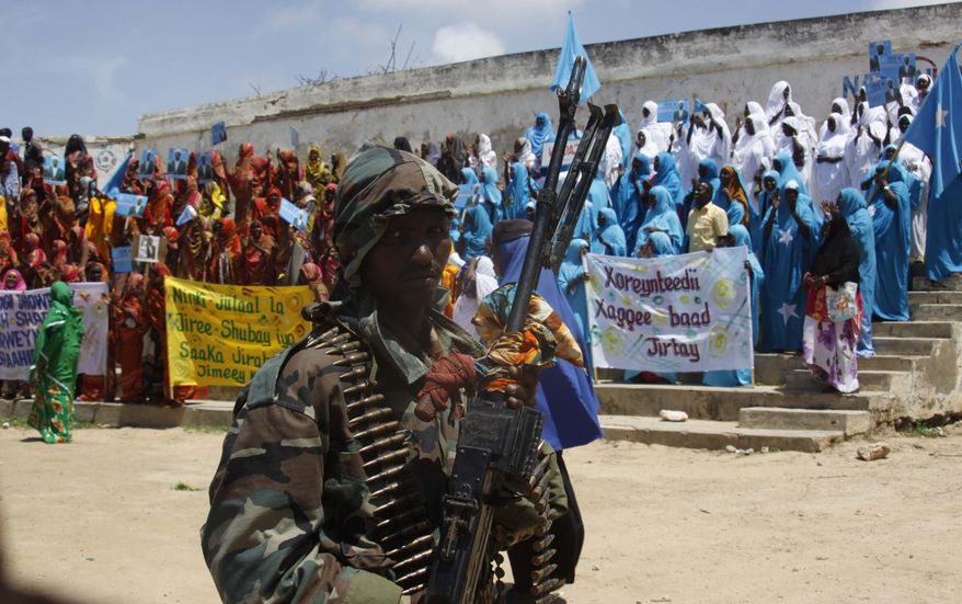 A Somali soldier stands guard Aug. 6, 2012, in Mogadishu as Somalis gather in a stadium. Somalis took to the streets to celebrate the one-year anniversary of the ouster of al Shabab militants, the culmination of years of warfare by African Union and Somali forces that has allowed Mogadishu bask in a year of relative peace. (Associated Press)