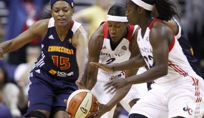 Connecticut Sun forward Asjha Jones, left, fights Washington Mystics center Michelle Snow, center, and guard Matee Ajavon for the ball during the first half of a WNBA basketball game on Friday, June 29, 2012, in Washington.  (AP Photo/ Evan Vucci)