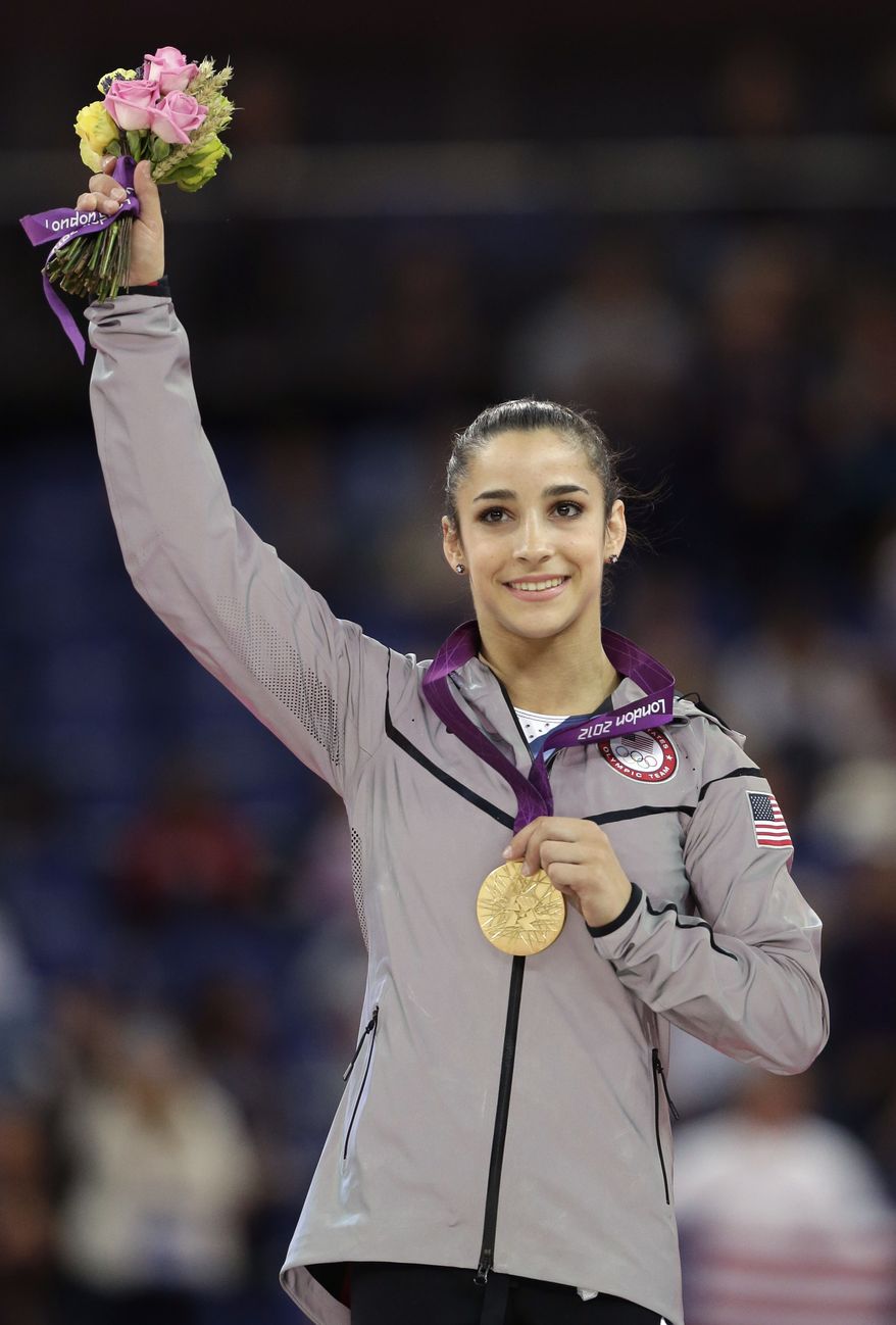 U.S. gymnast Aly Raisman displays her gold medal during the podium ceremony for the artistic gymnastics women's floor exercise final at the 2012 Summer Olympics, Tuesday Aug. 7, 2012, in London. (AP Photo/Gregory Bull)