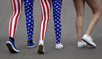 Nick Miller, left, and his sister Kendall Miller, center, from San Francisco, wear leotards in the colors of the United States national flag as they walk with a friend through Olympic Park at the 2012 Summer Olympics, in London. Patriotism and the games have always gone together, but gone are the days when one just waved a flag. Now flags are worn, seen all over London and especially at Olympic Park and other spots where the games are being played. (Associated Press)