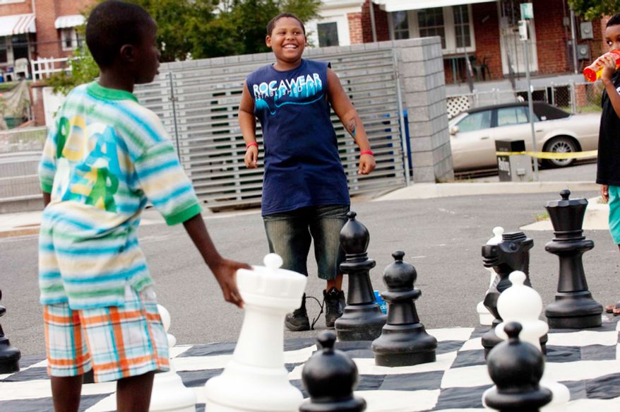 Kyree Wise, 9, plays a game of chess during the Seven District's National Night Out. Wise learned his chess skills from Blackanized INC, a organization that teaches chess and other life skills to young boys.(Raymond Thompson/The Washington Times)