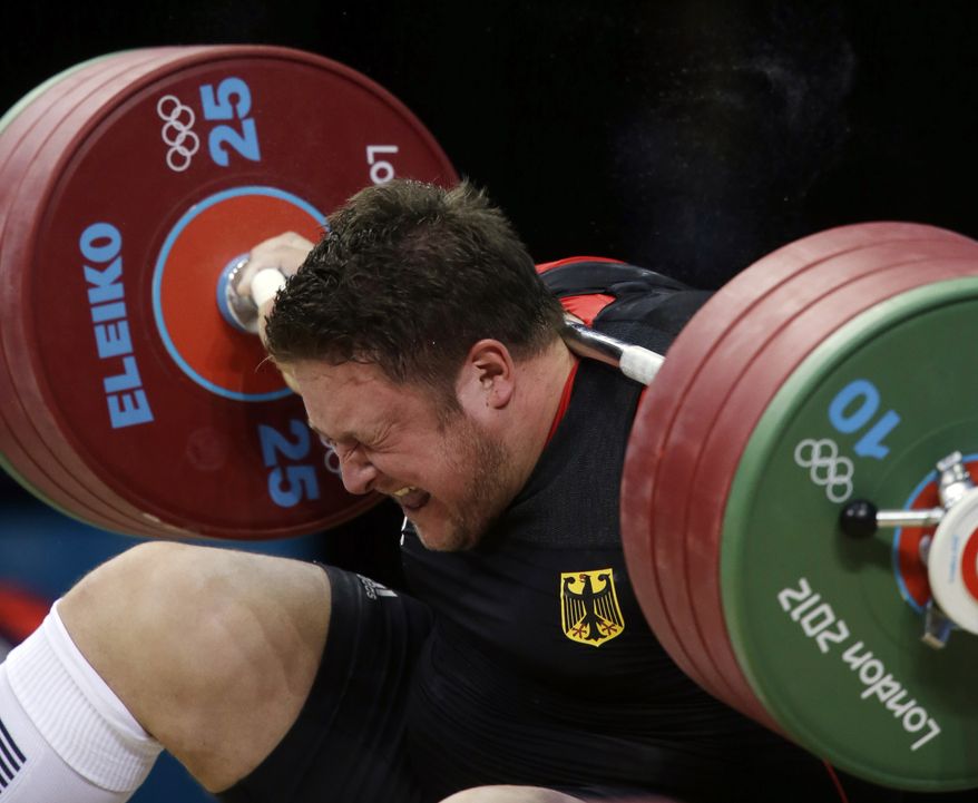 Matthias Steiner of Germany gets hit by the weights while failing to make a successful lift in the men's over 105-kg, group A, weightlifting competition at the 2012 Summer Olympics, Tuesday, Aug. 7, 2012, in London. (AP Photo/Mike Groll)
