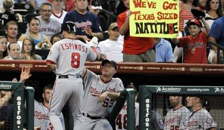 Washington Nationals&#39; Danny Espinosa (8) is welcomed back to the dugout by bench coach Randy Knorr (53) and fans after hitting a two-run home run against the Houston Astros in the second inning of a baseball game, Tuesday, Aug. 7, 2012, in Houston. (AP Photo/Pat Sullivan)