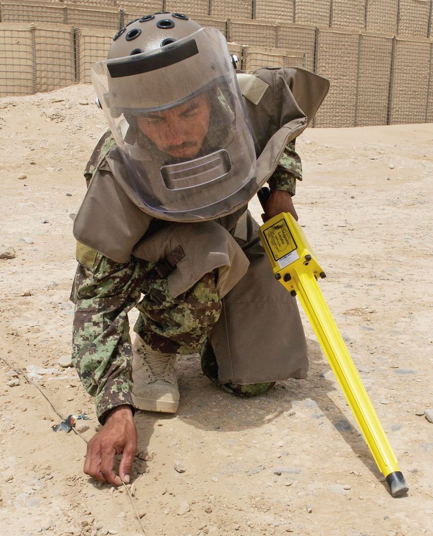 An Afghan soldier practices roadside bomb detection techniques at Camp Dwyer. NATO makes a high priority of sharing its bomb-related expertise with Afghan forces. (Associated Press)