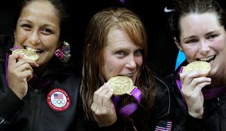 United States&#39; Brenda Villa, from left, Heather Petri and Jessica Steffens bite their gold medals during the women&#39;s water polo medal ceremony at the 2012 Summer Olympics, Thursday, Aug. 9, 2012, in London. The U.S. beat Spain 8-5. (AP Photo/Julio Cortez)