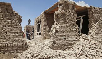 ** FILE ** An Afghan security man stands guard on the roof of a damaged house following a gun battle between militants and Afghan security forces on the outskirts of Kabul, Afghanistan, Thursday, Aug. 2, 2012. (AP Photo/Musadeq Sadeq)