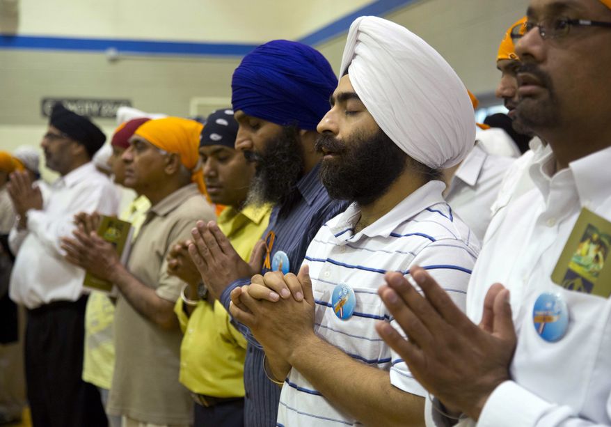 ** FILE ** Mourners attend the funeral and memorial service for the six victims of the Sikh temple of Wisconsin mass shooting in Oak Creek, Wis., on Aug. 10, 2012. (Associated Press)
