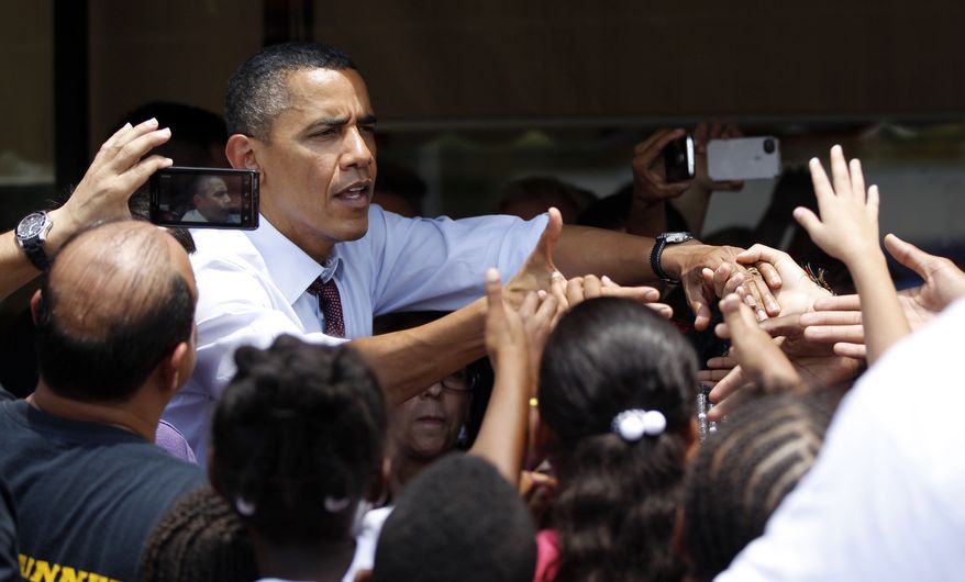 **FILE** President Obama greets people Aug. 2, 2012, outside Lechonera El Barrio, a local restaurant in Orlando, Fla. Obama won the 2008 election with 66% of the Hispanic vote and, according to polls, his popularity among the crucial voting bloc remains the same. (Associated Press)