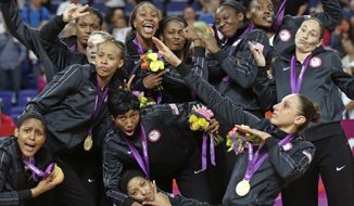 The United States&#39; basketball team pose with their gold medals at center court after beating France during the women&#39;s gold medal basketball game at the 2012 Summer Olympics, Saturday, Aug. 11, 2012, in London. (AP Photo/Charles Krupa)