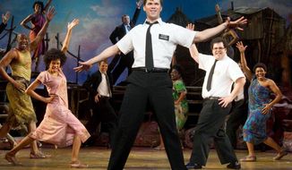 Andrew Rannells (center) performs with an ensemble cast in “The Book of Mormon” at the Eugene O’Neill Theatre in New York. The play starts a national tour this week led by Gavin Creel. “The Book of Mormon” was crowned best musical for its offensive yet good-natured look at two missionaries in Uganda. (Boneau/Bryan-Brown via Associated Press)