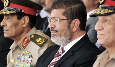 Egyptian Defense Minister Field Marshal Hussein Tantawi (left), President Mohammed Morsi (center) and Armed Forces Chief of Staff Gen. Sami Annan attend a medal ceremony at a military base east of Cairo last month. The president ordered the retirement of the defense minister and chief of staff on Sunday. (Associated Press)