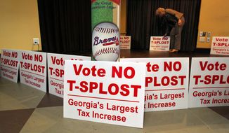 Debbie Dooley, co-founder of the Atlanta Tea Party, sets out signs and waits for returns as groups opposing a proposed sales tax increase that would have raised billions of dollars for transportation projects gather for a election night watch at Hudson Grille in Atlanta on Tuesday, July 31, 2012. (AP Photo/Atlanta Journal-Constitution, Curtis Compton)