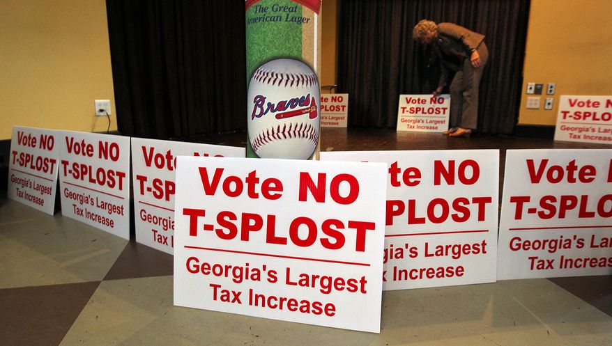 Debbie Dooley, co-founder of the Atlanta Tea Party, sets out signs and waits for returns as groups opposing a proposed sales tax increase that would have raised billions of dollars for transportation projects gather for a election night watch at Hudson Grille in Atlanta on Tuesday, July 31, 2012. (AP Photo/Atlanta Journal-Constitution, Curtis Compton)