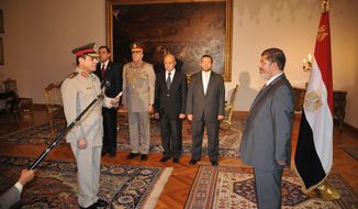 Egyptian President Mohammed Morsi (right) swears in the newly-appointed defense minister, Lt. Gen. Abdel-Fattah el-Sissi, in Cairo on Sunday, Aug. 12, 2012. (AP Photo/Egyptian Presidency)