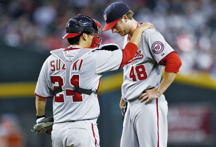 Everything is new for Washington catcher Kurt Suzuki, particularly the pitchers (shown with Ross Detwiler). (Associated Press)
