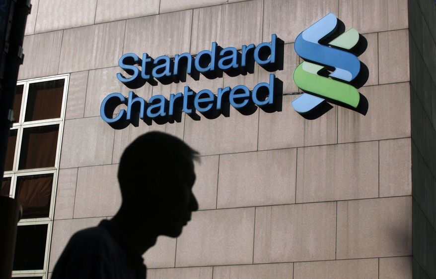 A man walks past the Standard Chartered Bank building in Hong Kong in October 2010. (AP Photo/Kin Cheung)