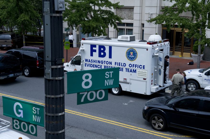 FBI and Metropolitan Police Department officials surround the Family Research Council building at 8th and G streets N.W. in Washington, D.C., on Wednesday, Aug. 15, 2012, following the shooting of a security guard at the conservative Christian lobbying group. The security guard was evidently shot in the arm before he wrestled the gunman to the ground. The suspect has now been taken into custody. (Barbara L. Salisbury/The Washington Times)