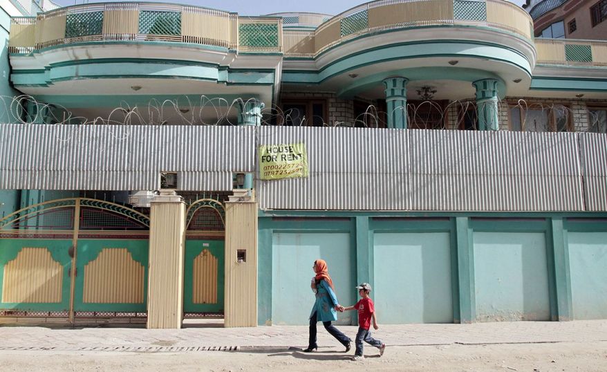 Afghans walk past by a house for rent in Kabul, Afghanistan. A real estate broker, Mir Ahmad Shah, said the market is the worst in his seven years of selling properties in the capital. No one wants to buy due to instability and the 2014 departure of NATO forces. (Associated Press)