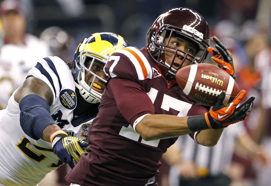 Virginia Tech cornerback Kyle Fuller (17) intercepts a pass intended for Michigan wide receiver Junior Hemingway (21) during the first quarter of the Sugar Bowl NCAA college football game in New Orleans, Tuesday, Jan. 3, 2012. (AP Photo/Dave Martin)