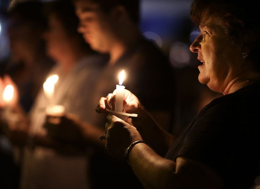 Denise Recatto (right) of Baton Rouge, La., sings with other Elvis Presley fans during the annual candlelight vigil at Graceland, Presley's home in Memphis, Tenn., on Wednesday, Aug. 15, 2012. (AP Photo/Mark Humphrey)
