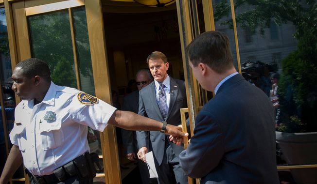 Escorted by a security guard, Family Research Council President Tony Perkins arrives to offer remarks and field questions from reporters outside of the Family Research Council headquarters in Washington, D.C., Thursday, August 16, 2012. (Rod Lamkey Jr./The Washington Times)
