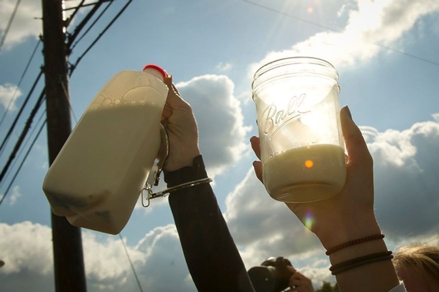 Demonstrators raise glasses and jugs of raw milk in a toast Nov. 1, 2011, during a protest in front of the Food and Drug Administration headquarters in Silver Spring, Md. The FDA has banned interstate transportation of raw milk. The milk used during the demonstration was picked up in Pennsylvania and transported to Maryland. (Rod Lamkey Jr./The Washington Times)