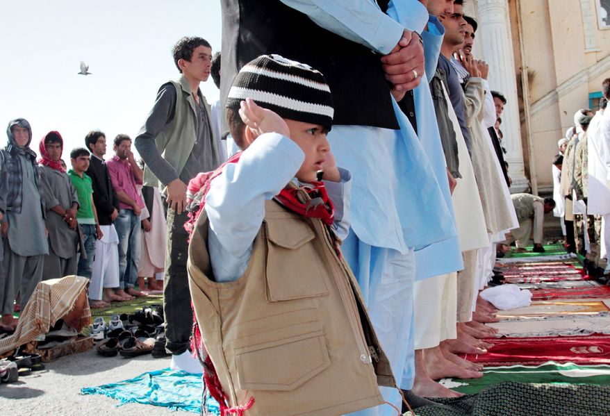 Afghans offer Eid al-Fitr holiday prayers Sunday at a mosque in Kabul at the end of Ramadan. “The enemies of Muslims … during the holy month of Ramadan treated the nation of Afghanistan cruelly: bombs, explosions in mosques, suicide attacks in mosques,” President Hamid Karzai said. (Associated Press)